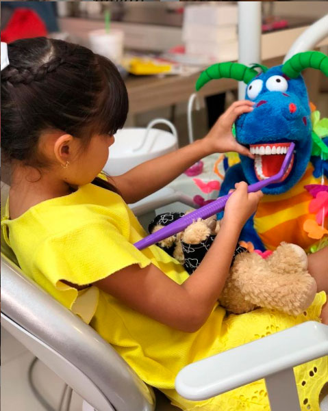 niñas cepillando los dientes de juguete